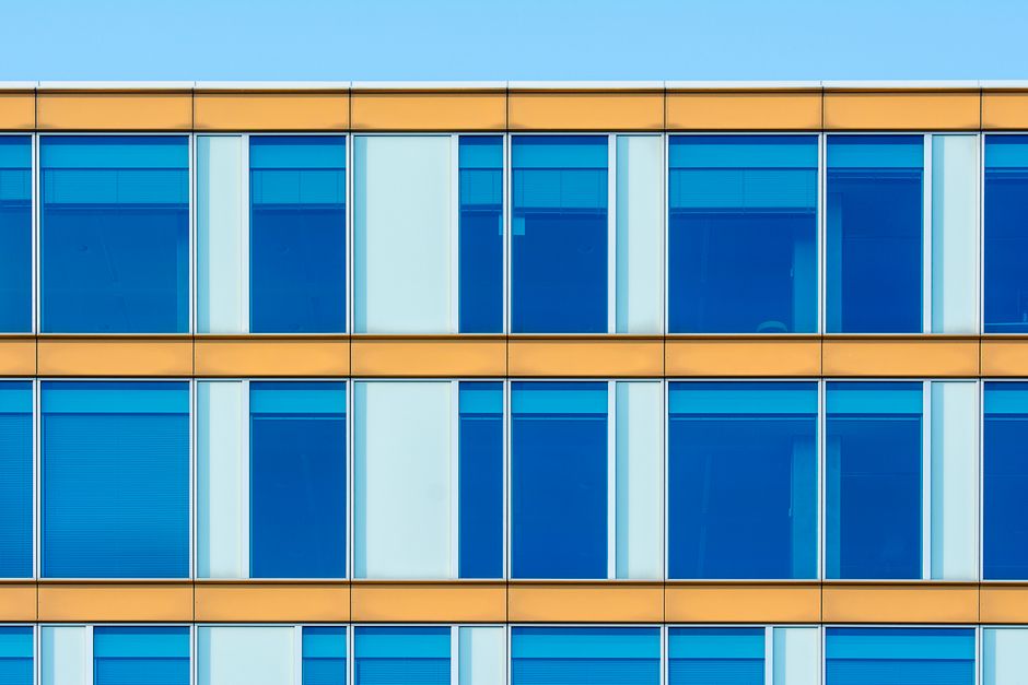 Contemporary office building facade showcasing blue windows and yellow structure